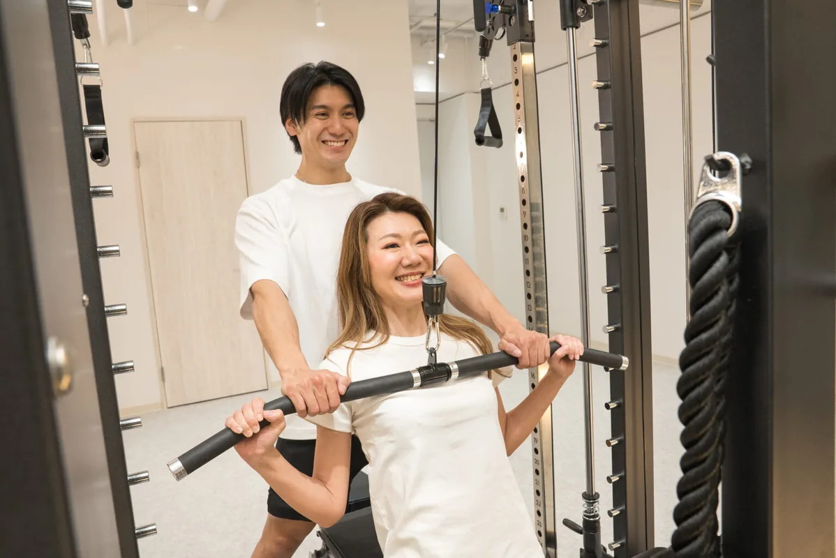 背中のトレーニングをサポートしている様子